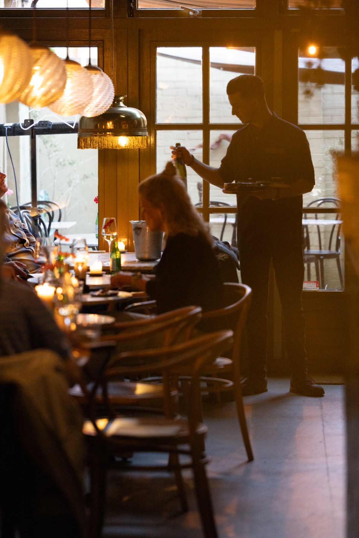 Wijn wordt ingeschonken aan een volle tafel